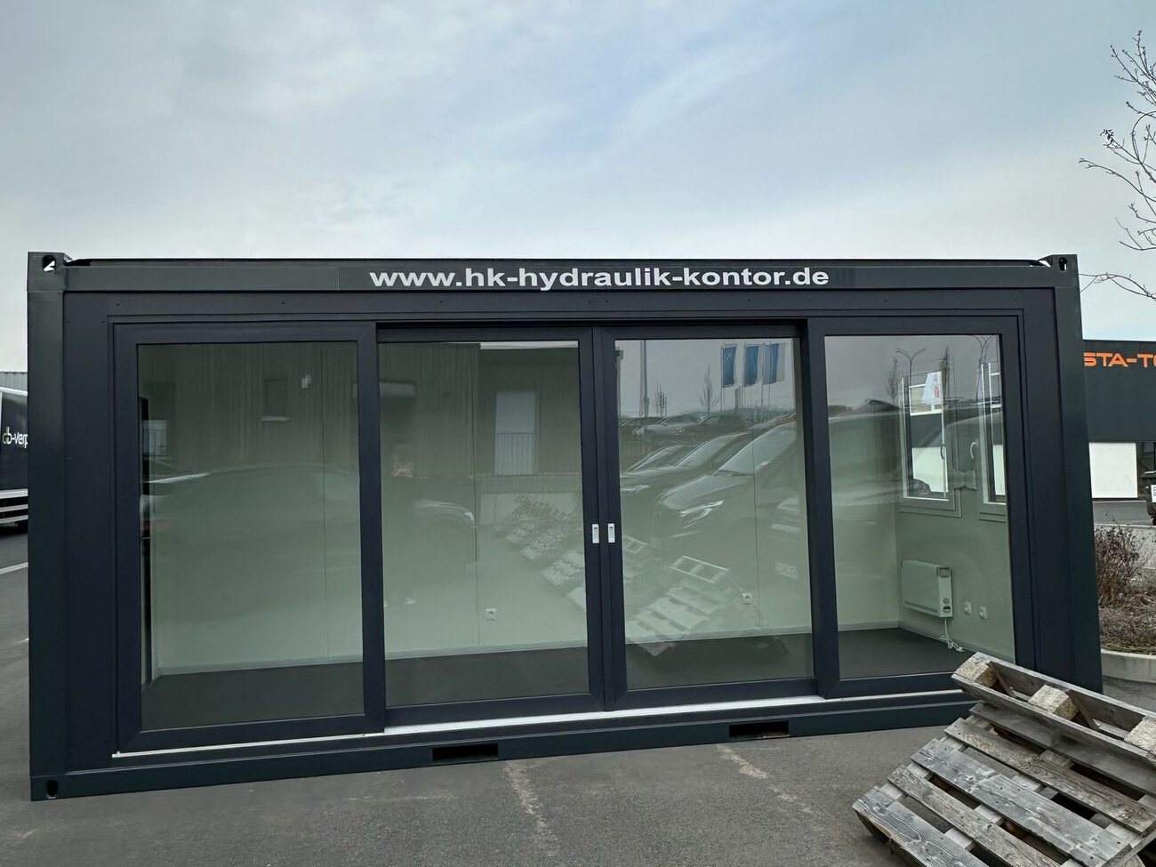 Zum Showroom umgebauter Container mit kompletter Glasfront